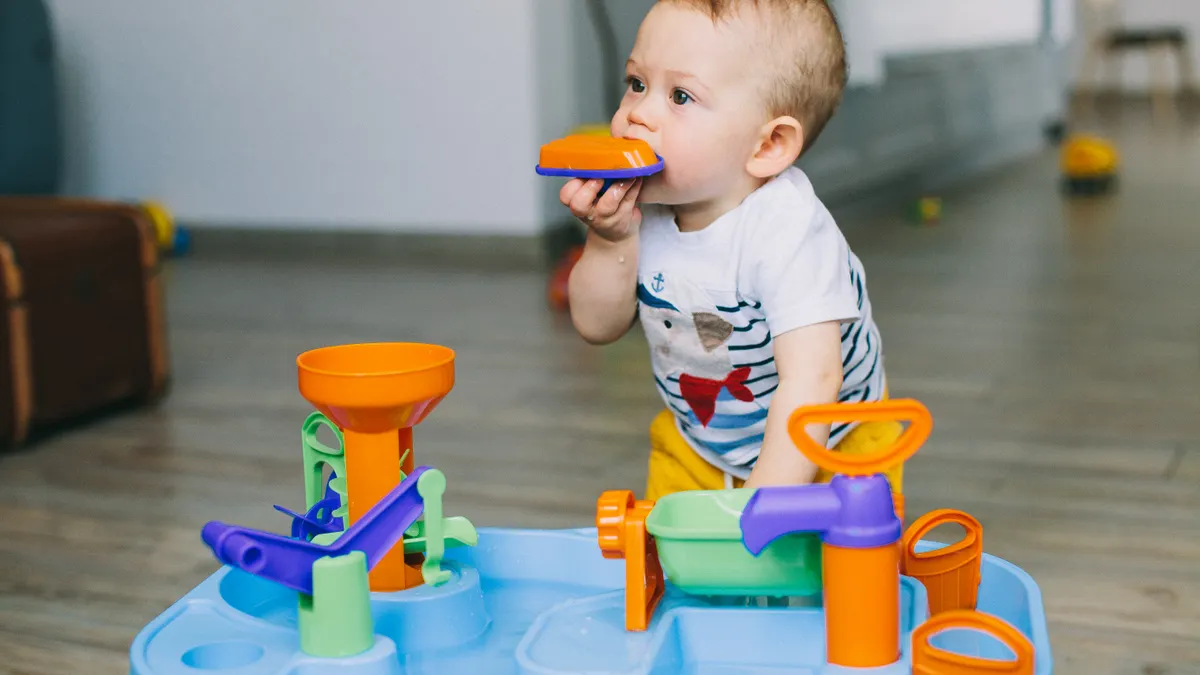 How to Choose Safe Sensory Toys for Toddlers Toddler using a sensory play toy table