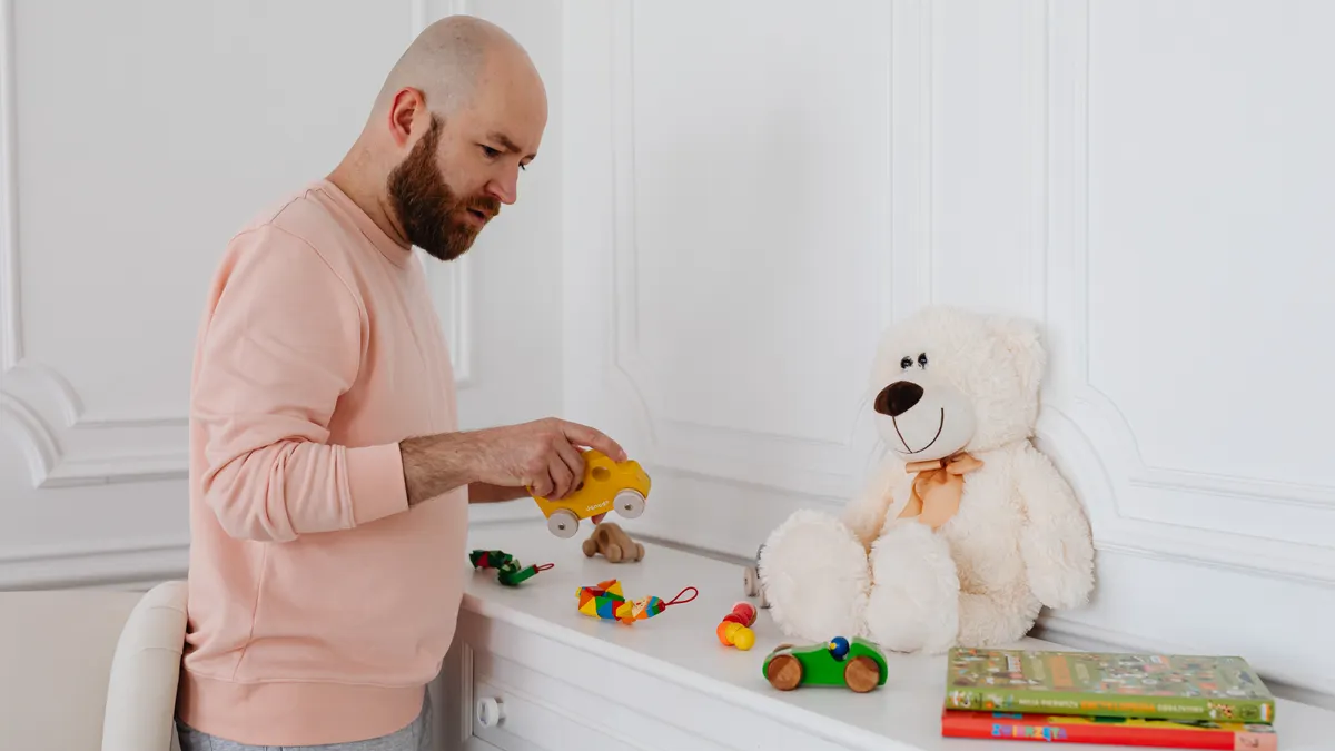 How to Clean and Sanitize Toddler Toys Without Damaging Them Man cleaning small toys on a shelf